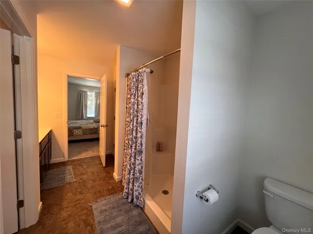 a view of bathroom with tub shower and bedroom
