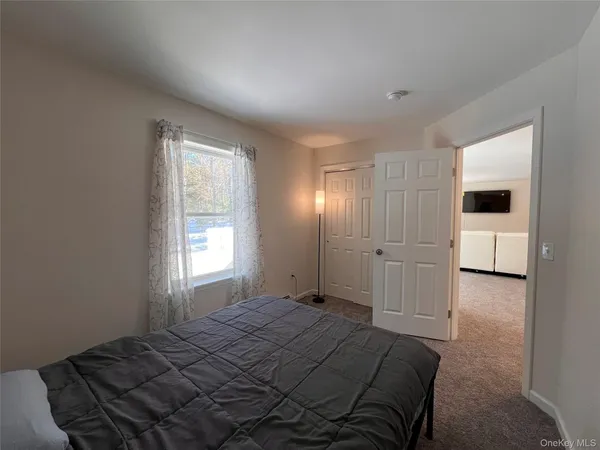 an empty room with wooden floor staircase and windows