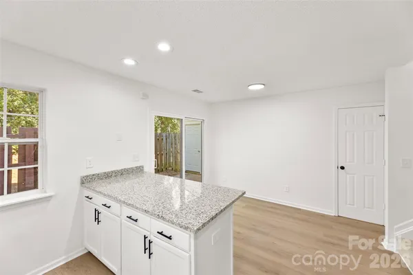 a kitchen with granite countertop a sink and a wooden floor