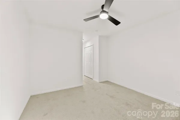an empty room with a ceiling fan and a window