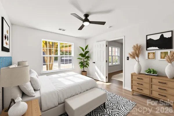 a spacious bedroom with a bed and wooden floor