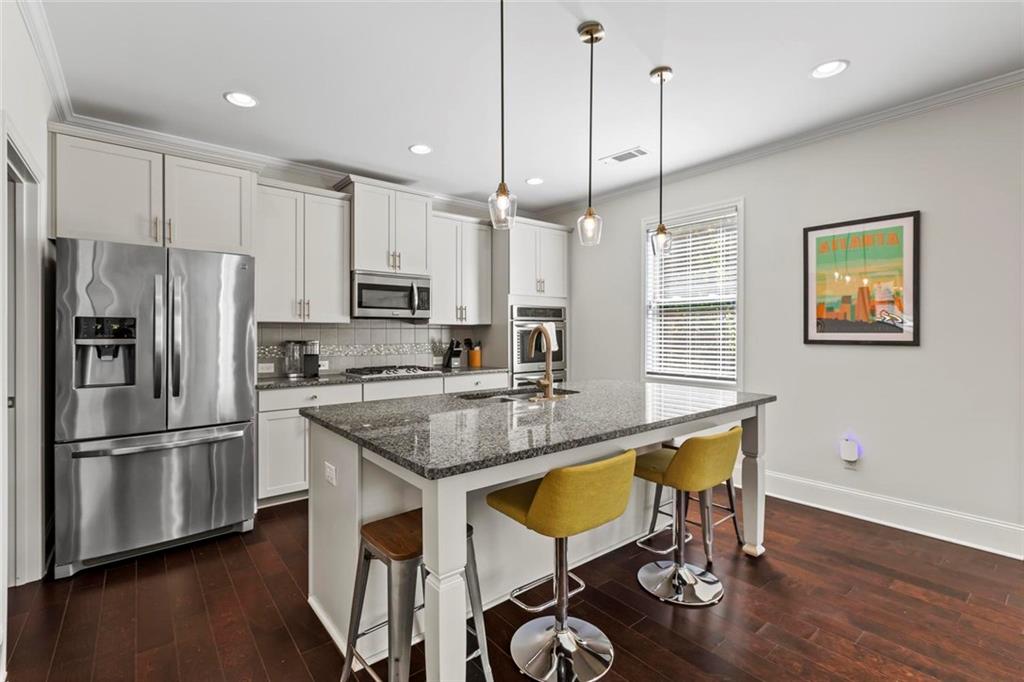 2426 Fair Oaks Way Atlanta, GA 30337 - Photo 14 of 29 a kitchen with stainless steel appliances granite countertop a refrigerator a stove a sink a oven a dining table and chairs with wooden floor