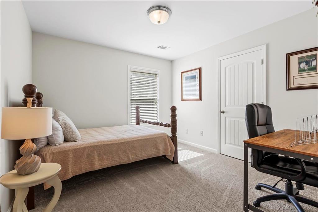 2426 Fair Oaks Way Atlanta, GA 30337 - Photo 22 of 29 a bedroom with a bed and a table in it