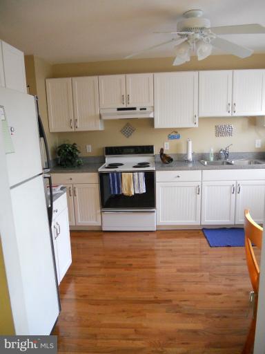 9321 Pan Ridge Road, Unit 9321 Parkville, MD 21234 - Photo 22 of 30 a kitchen with granite countertop a sink a stove a refrigerator and cabinets