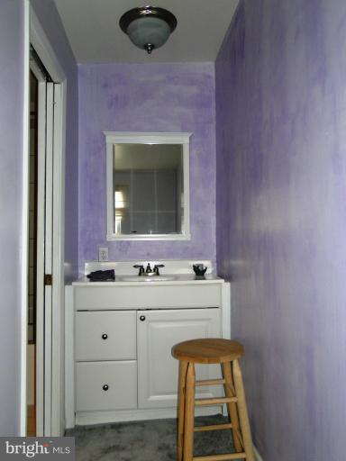 9321 Pan Ridge Road, Unit 9321 Parkville, MD 21234 - Photo 7 of 30 a bathroom with a sink a mirror and a window