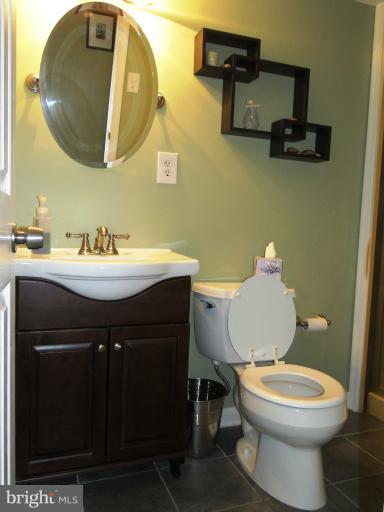9321 Pan Ridge Road, Unit 9321 Parkville, MD 21234 - Photo 8 of 30 a bathroom with a toilet a sink and mirror