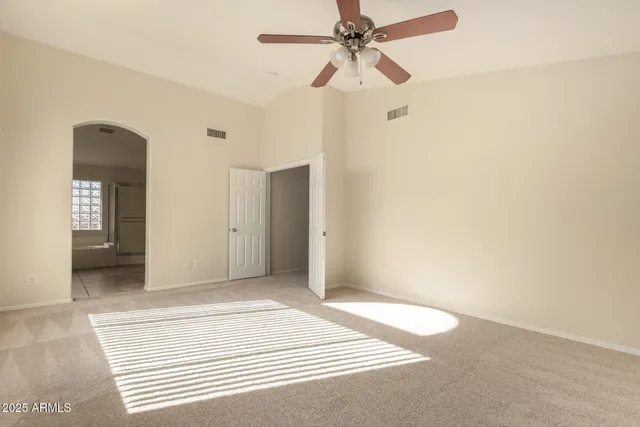 an empty room with fan and entrance
