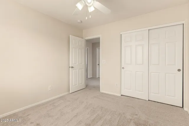 an empty room with a chandelier fan