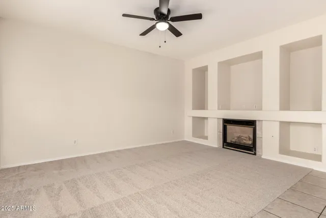 an empty room with a fireplace and cabinet