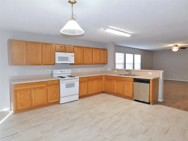 a kitchen with granite countertop a sink cabinets and stainless steel appliances