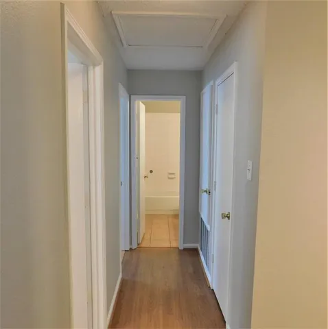a view of a hallway with wooden floor
