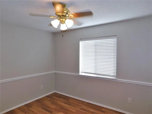 a view of a small space with wooden floor and a window