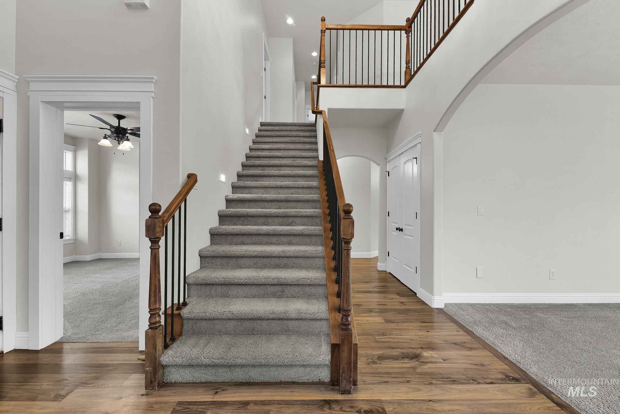 2172 West Cedar Grove Street Meridian, ID 83646 - Photo 26 of 49 Grand staircase featuring carpeted treads and wood handrails with black metal spindles