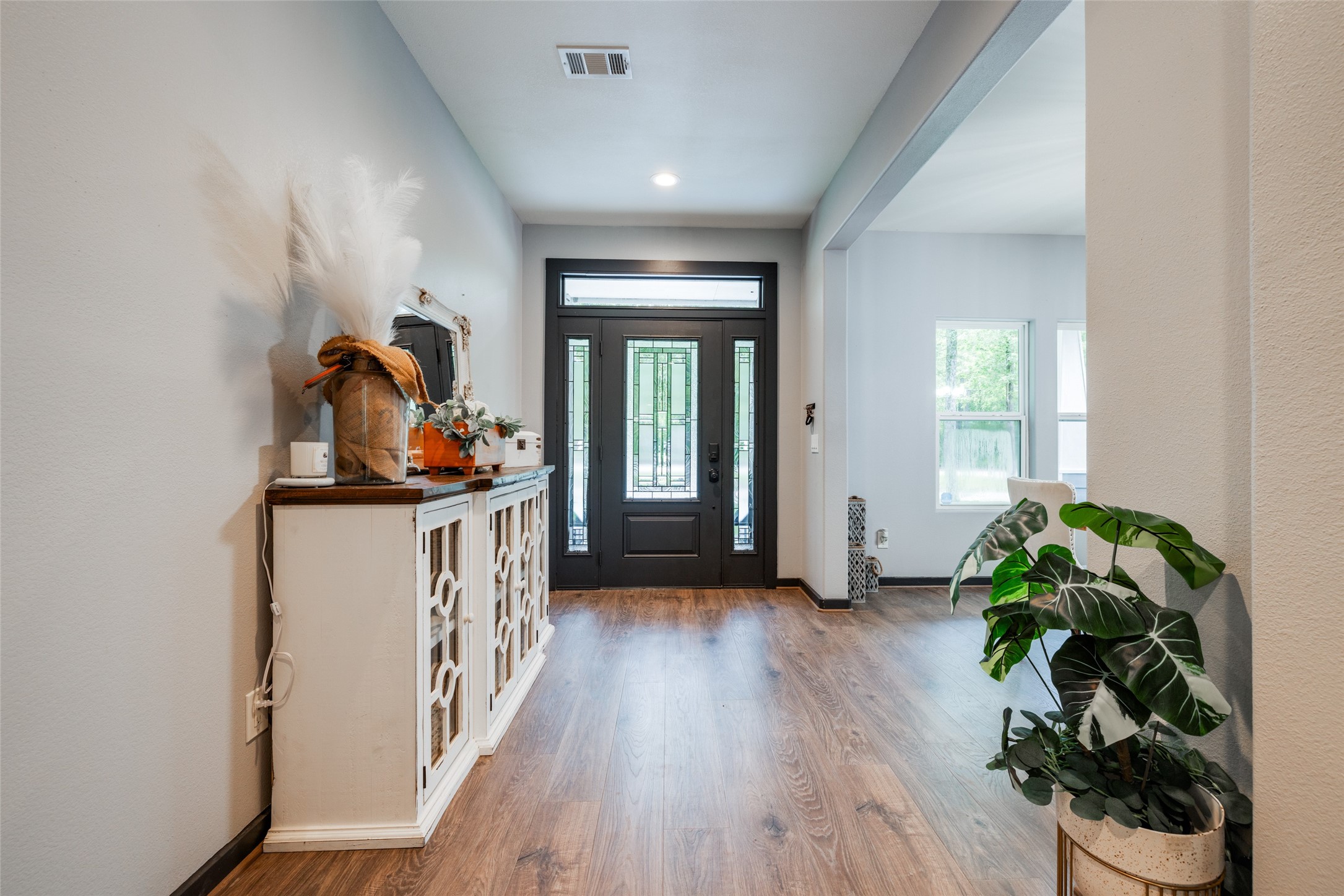35 Disher Circle Huffman, TX 77336 - Photo 7 of 50 a hallway with wooden floor and three potted plants