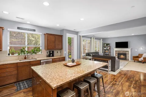 a kitchen with granite countertop a table chairs sink and cabinets