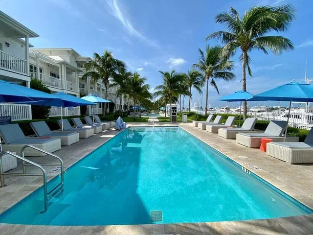 a view of a swimming pool with a lawn chairs under an umbrella