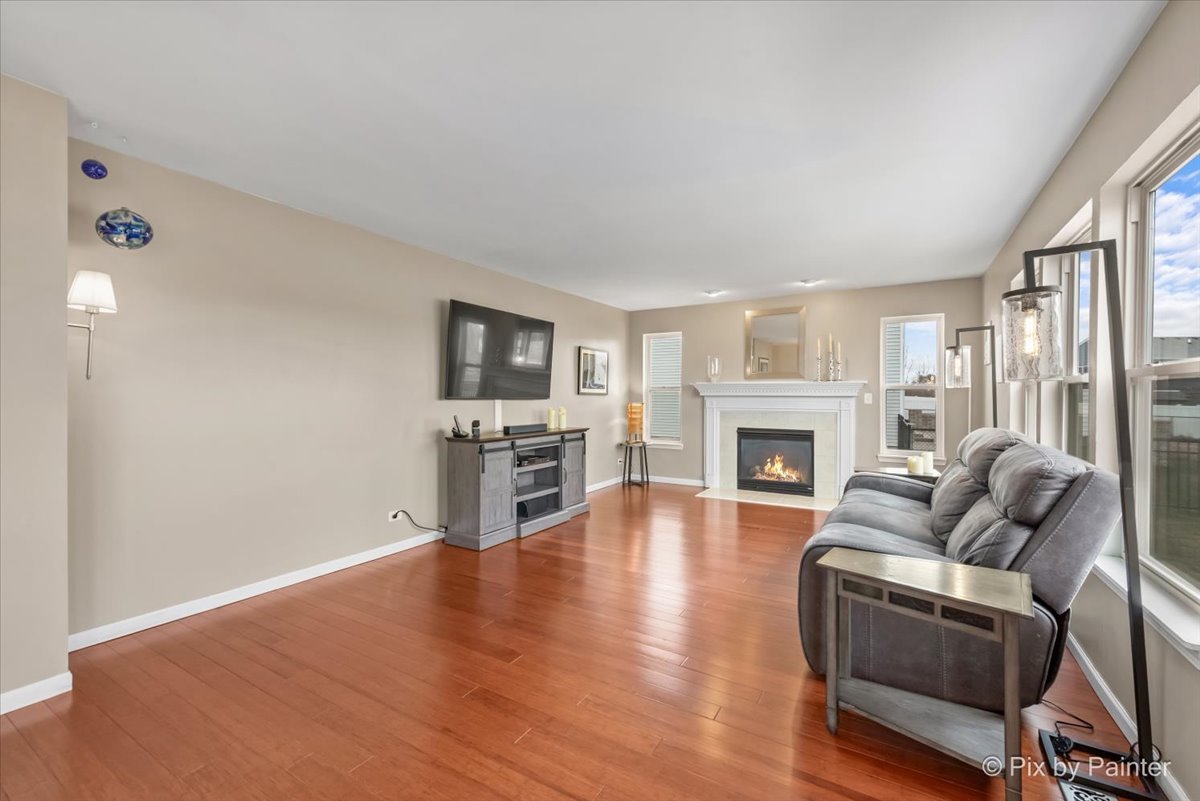 4902 Stillwater Road Wonder Lake, IL 60097 - Photo 15 of 46 a living room with furniture a fireplace and a flat screen tv