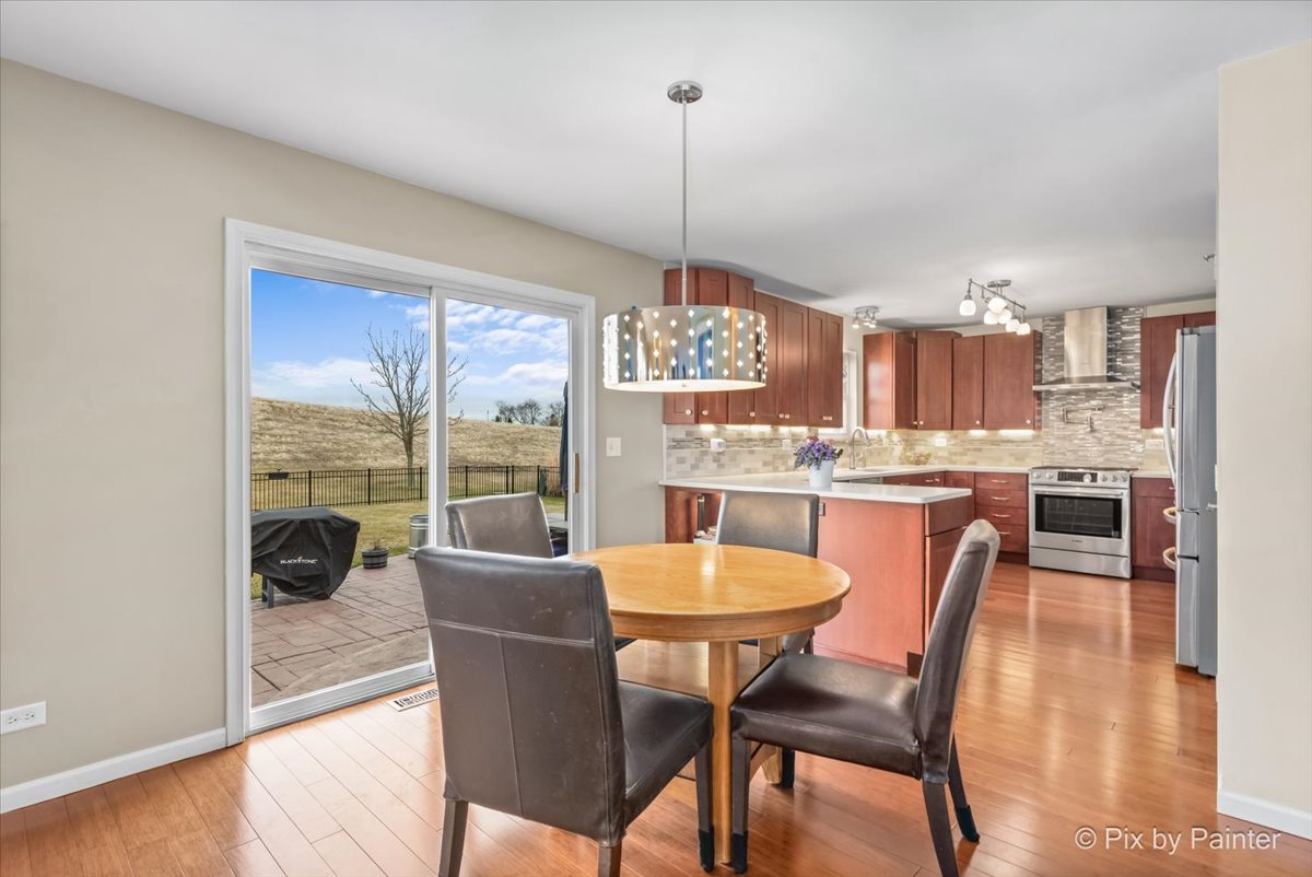 4902 Stillwater Road Wonder Lake, IL 60097 - Photo 2 of 46 a dining room with furniture a chandelier and wooden floor