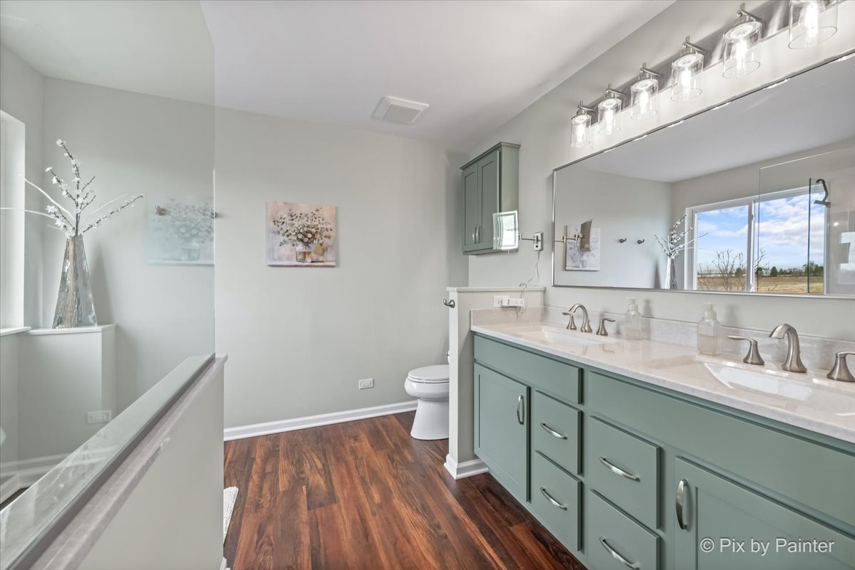 4902 Stillwater Road Wonder Lake, IL 60097 - Photo 29 of 46 a bathroom with a double vanity sink toilet and a mirror