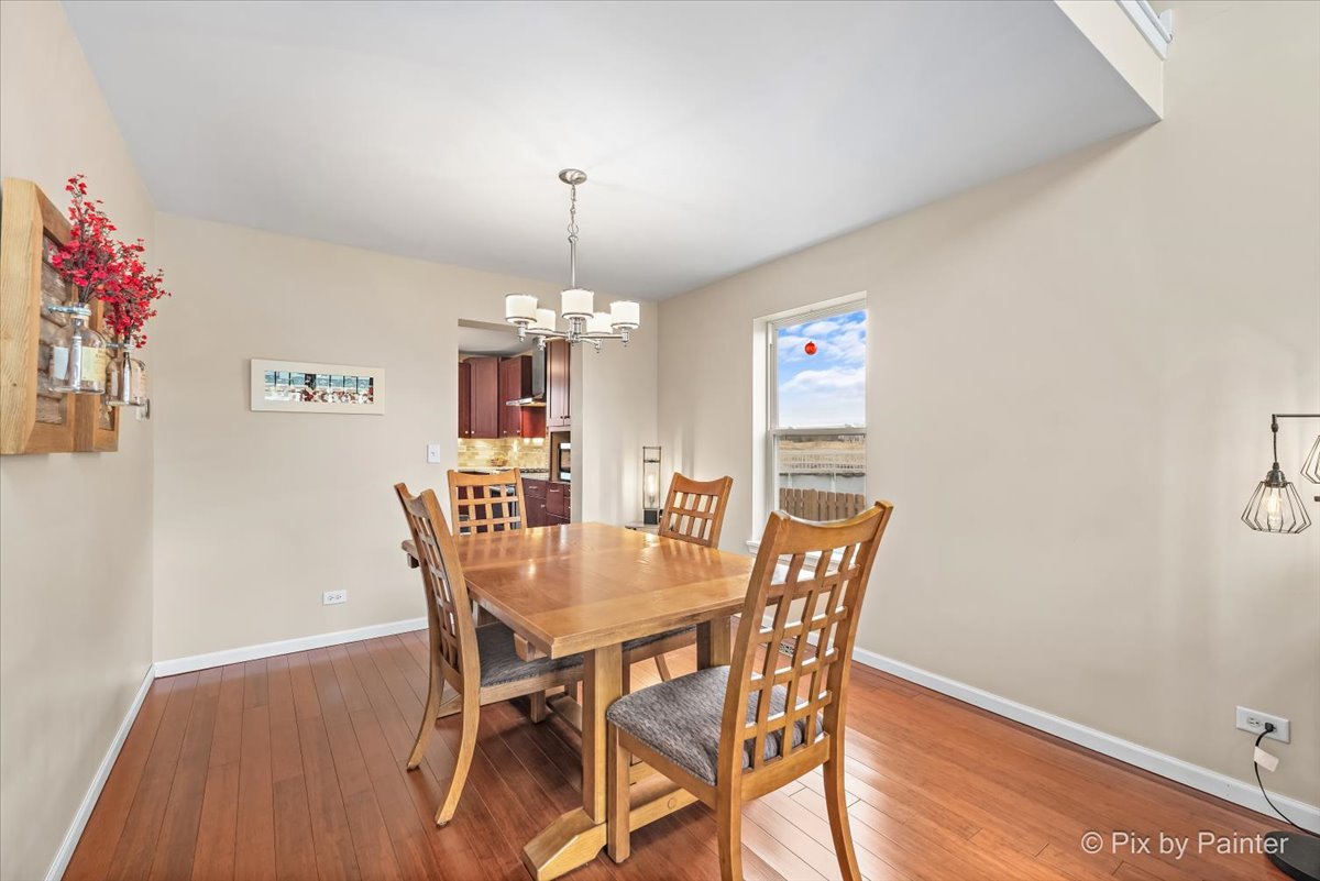 4902 Stillwater Road Wonder Lake, IL 60097 - Photo 7 of 46 a view of a dining room with furniture wooden floor and chandelier