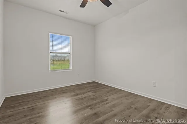 an empty room with a window and a ceiling fan