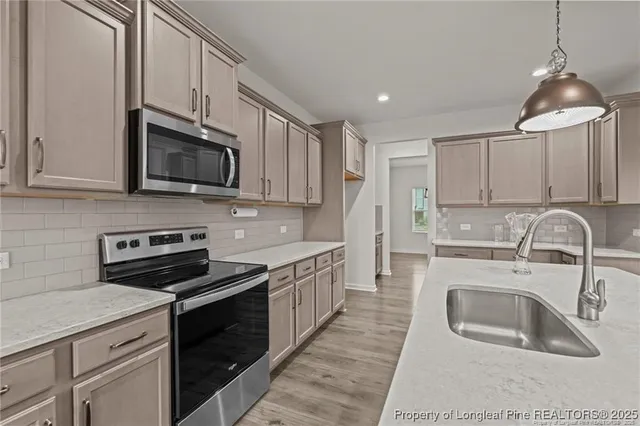 a kitchen with stainless steel appliances granite countertop a sink stove a microwave and cabinets