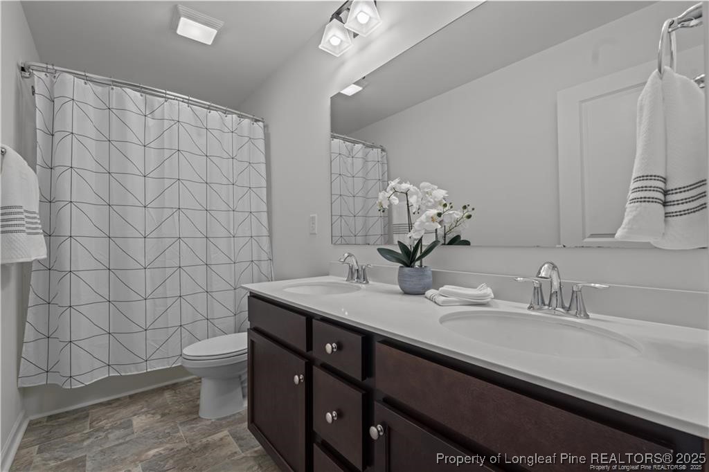 40 Arlie Lane Lillington, NC 27546 - Photo 32 of 39 a bathroom with a sink a toilet and mirror