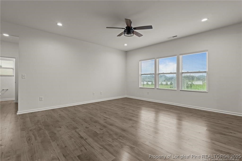 40 Arlie Lane Lillington, NC 27546 - Photo 7 of 39 an empty room with wooden floor chandelier fan and windows
