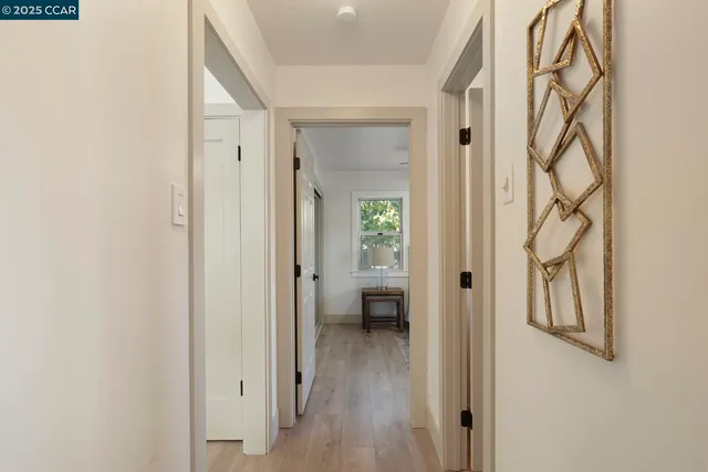 a view of a hallway with wooden floor and closet