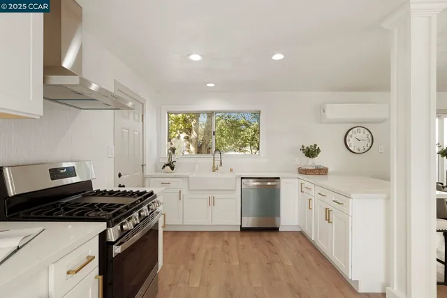 a kitchen with stainless steel appliances a stove and white cabinets