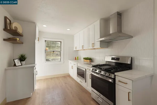 a kitchen with stainless steel appliances a sink dishwasher stove and white cabinets with wooden floor