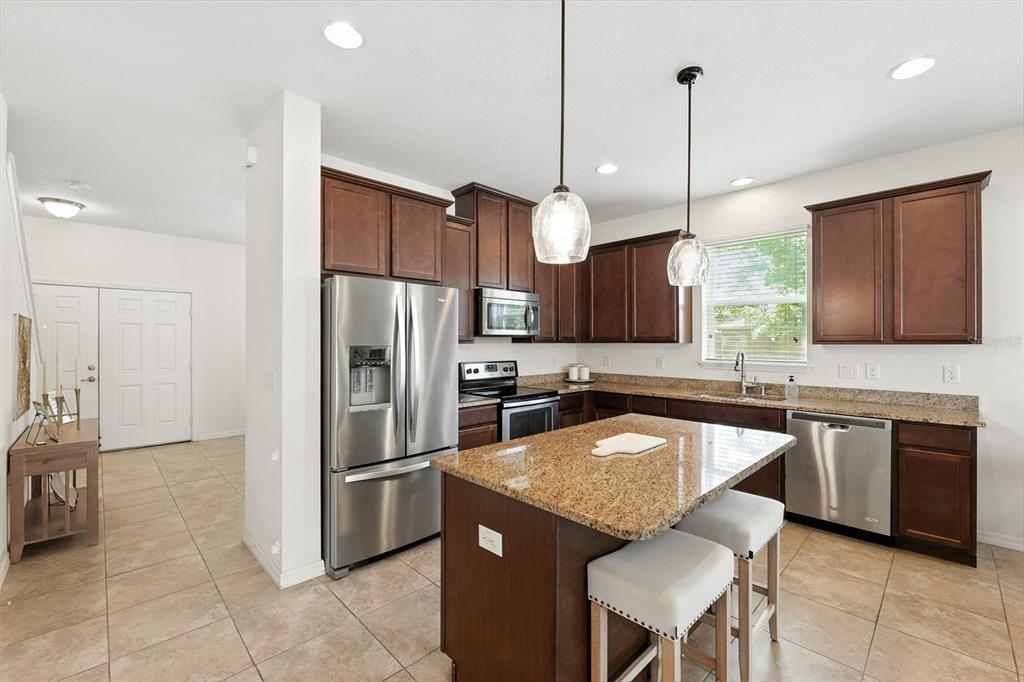 1653 Nature View Drive Lutz, FL 33558 - Photo 11 of 63 a kitchen with stainless steel appliances granite countertop a sink a stove a refrigerator and island