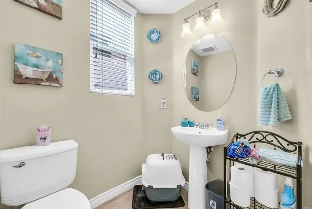 a bathroom with a toilet sink and mirror