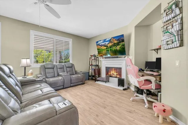 a living room with furniture a flat screen tv and a fireplace