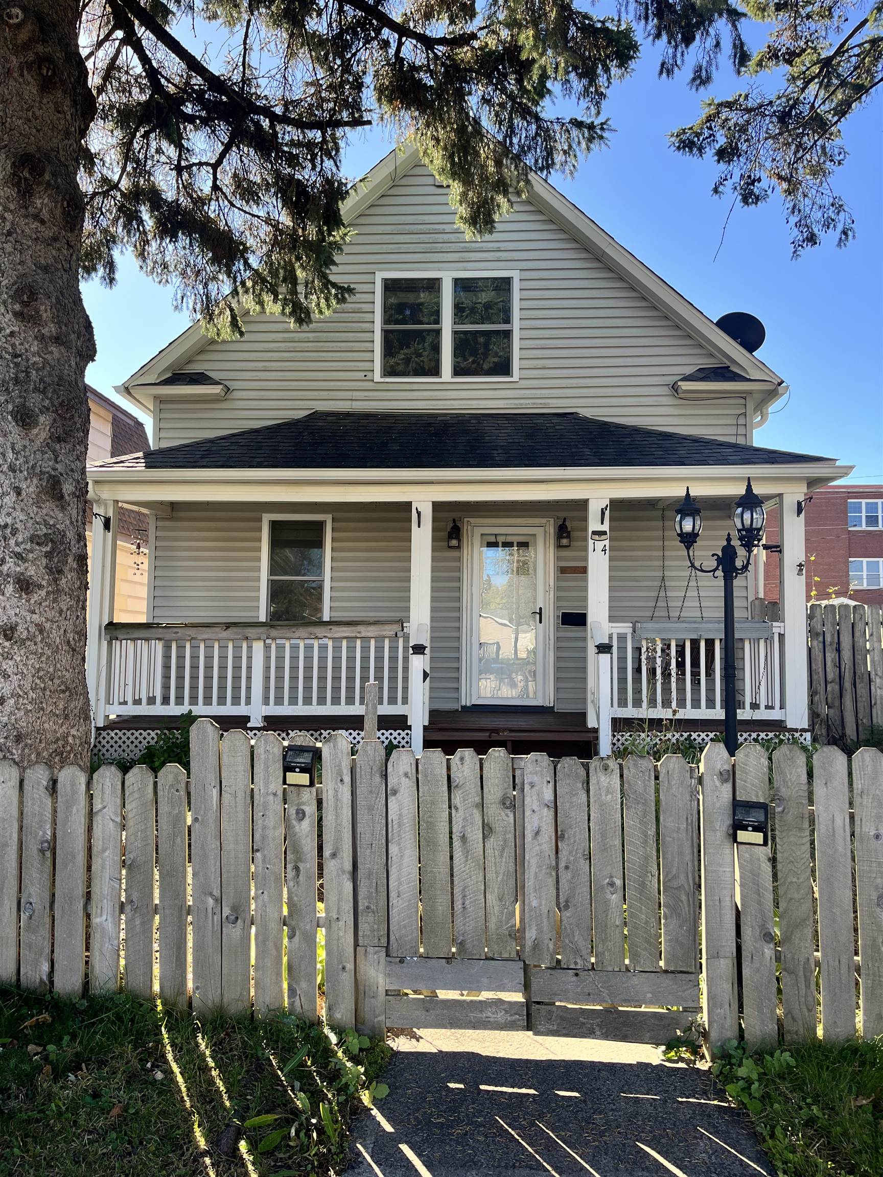 View of front of property featuring a porch and a fenced front yard