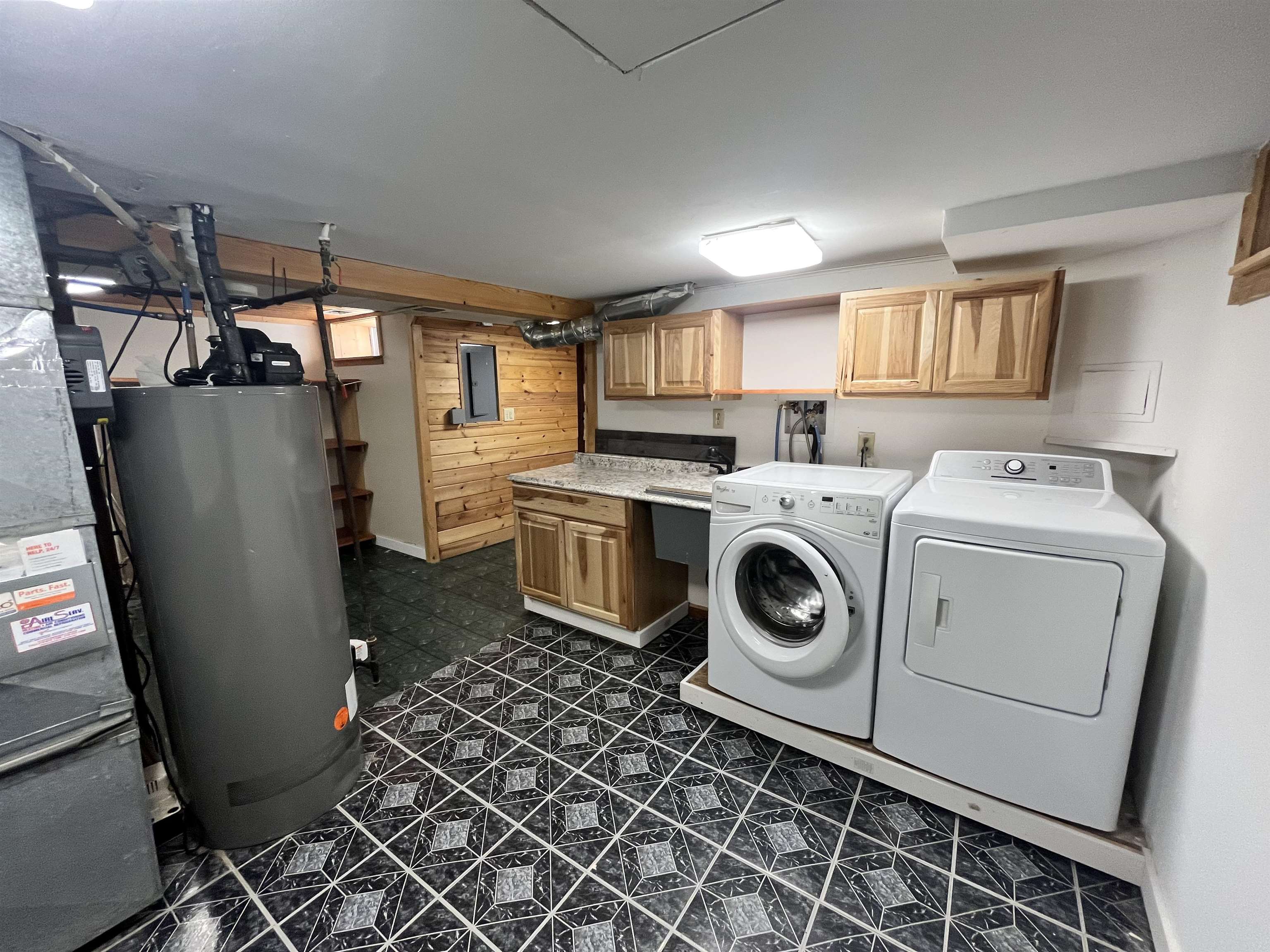 14 3rd Street Proctor, MN 55810 - Photo 18 of 19 Laundry area featuring water heater, washing machine and dryer, dark flooring, cabinet space, and heating unit