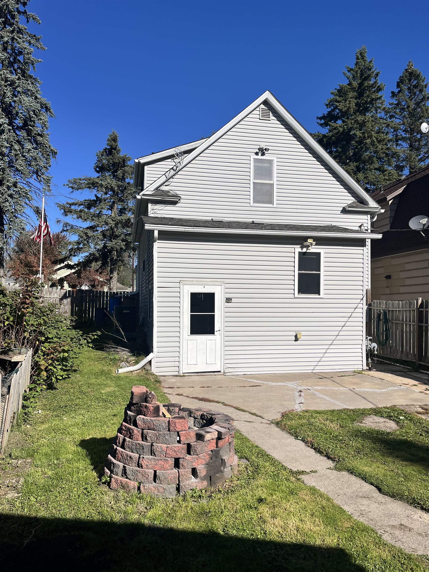 14 3rd Street Proctor, MN 55810 - Photo 19 of 19 Rear view of house with an outdoor fire pit and a patio area