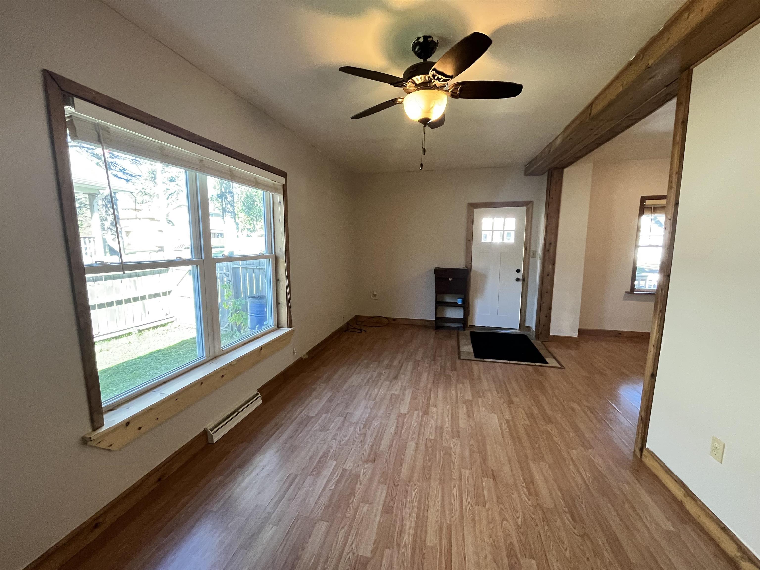 14 3rd Street Proctor, MN 55810 - Photo 2 of 19 Unfurnished living room with wood finished floors, a ceiling fan, and baseboard heating