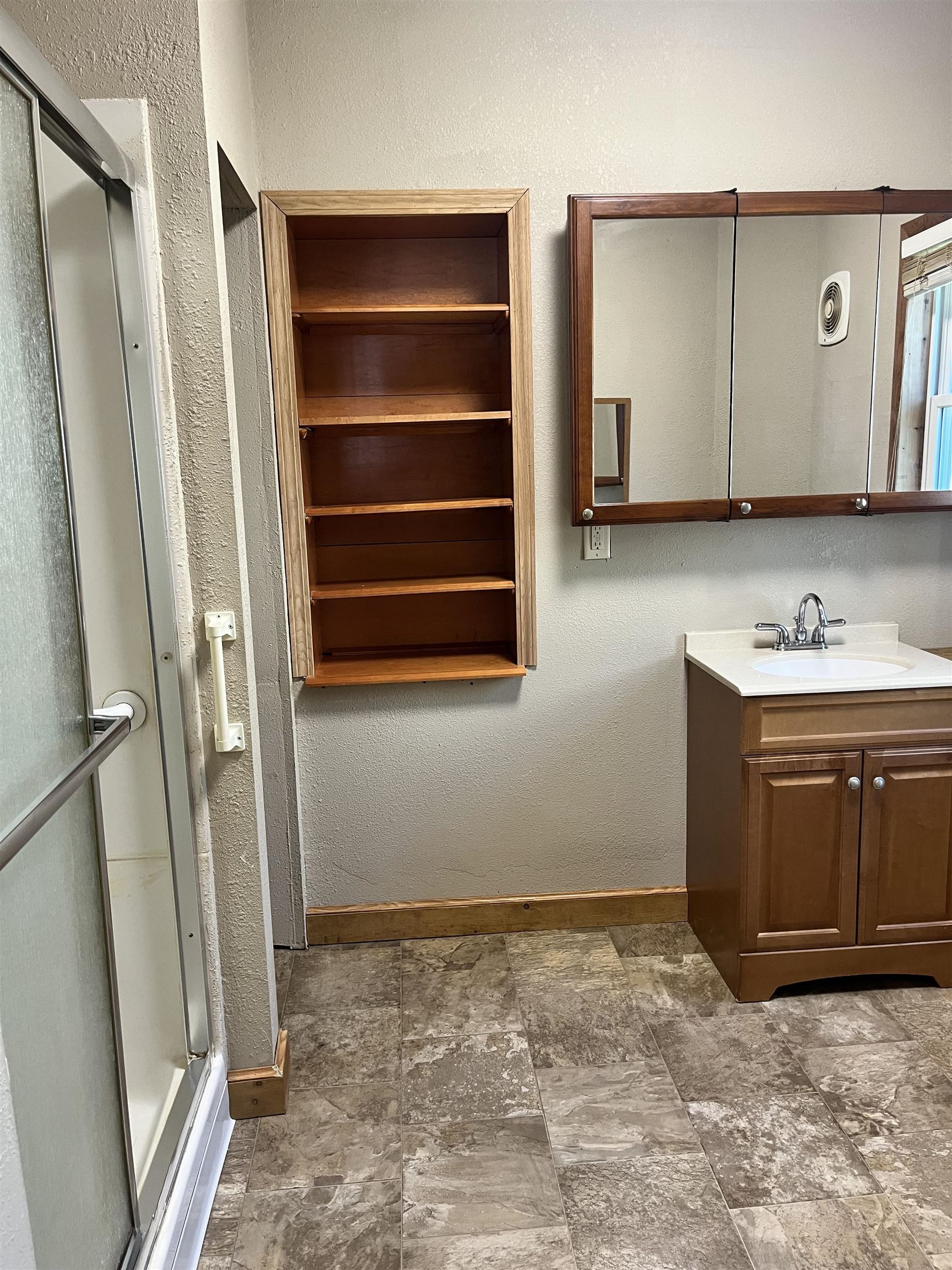 14 3rd Street Proctor, MN 55810 - Photo 5 of 19 Bathroom featuring a textured wall, vanity, a stall shower, and dark stone finish flooring