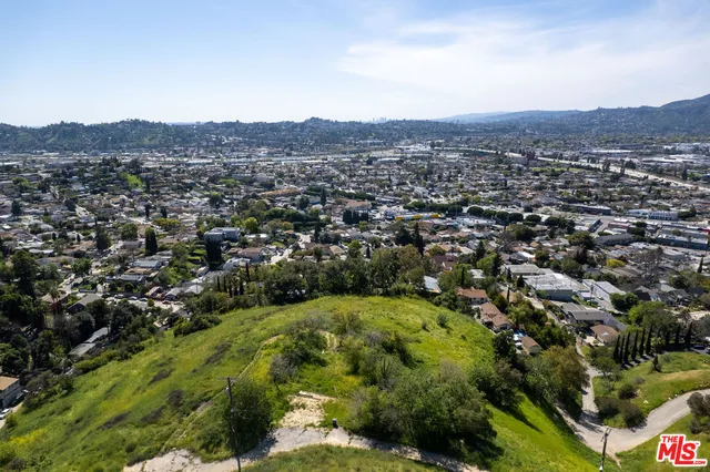 an aerial view of residential houses with outdoor space and trees