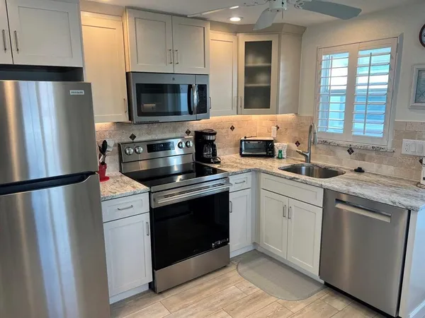 a view of a kitchen area with furniture and wooden floor