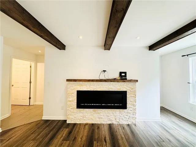 a view of a livingroom with wooden floor and a fireplace