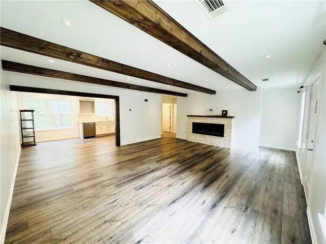 a view of empty room with wooden floor and fireplace
