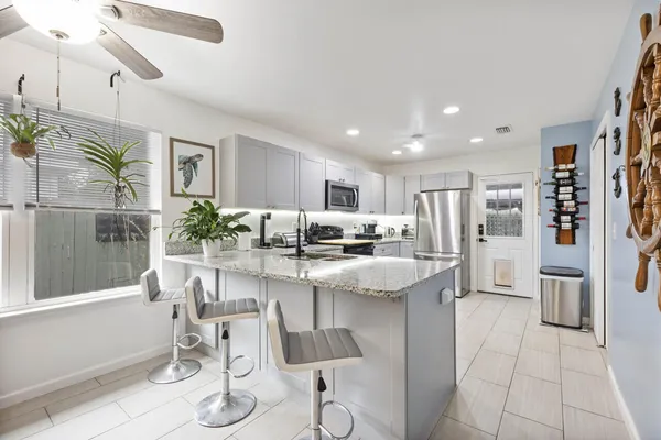 a kitchen with granite countertop white cabinets and white appliances