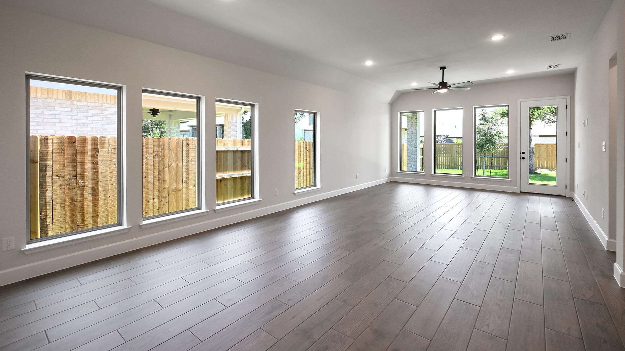 126 Basket Flower Loop Kyle, TX 78640 - Photo 12 of 29 a view of an empty room with wooden floor and a window