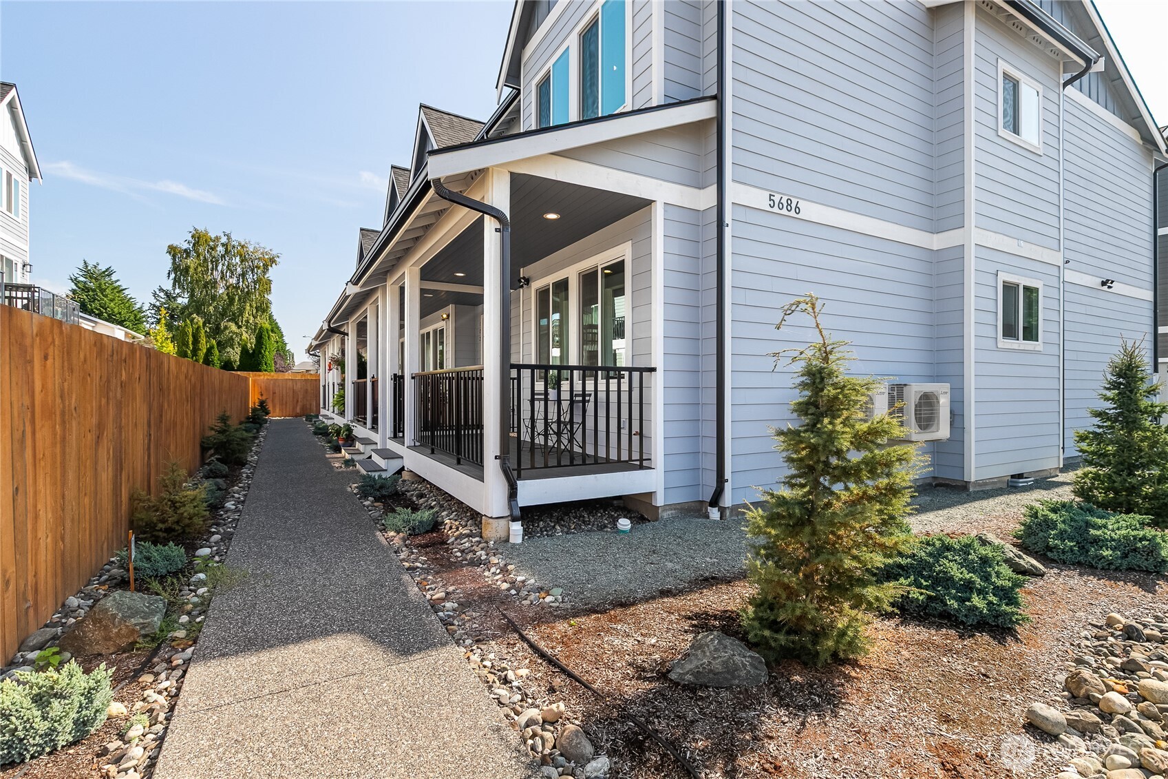 5686 Sunstone Place, Unit 101 Ferndale, WA 98248 - Photo 2 of 32 a view of a house with wooden fence next to a yard