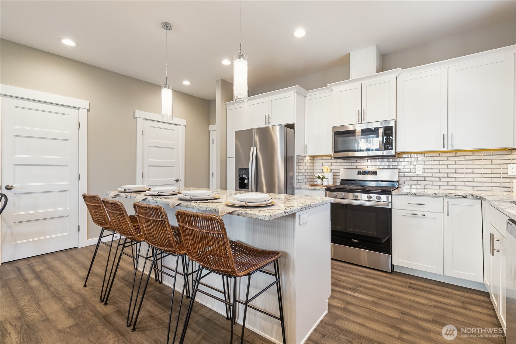 5686 Sunstone Place, Unit 101 Ferndale, WA 98248 - Photo 8 of 32 a kitchen with stainless steel appliances a white table chairs and a refrigerator