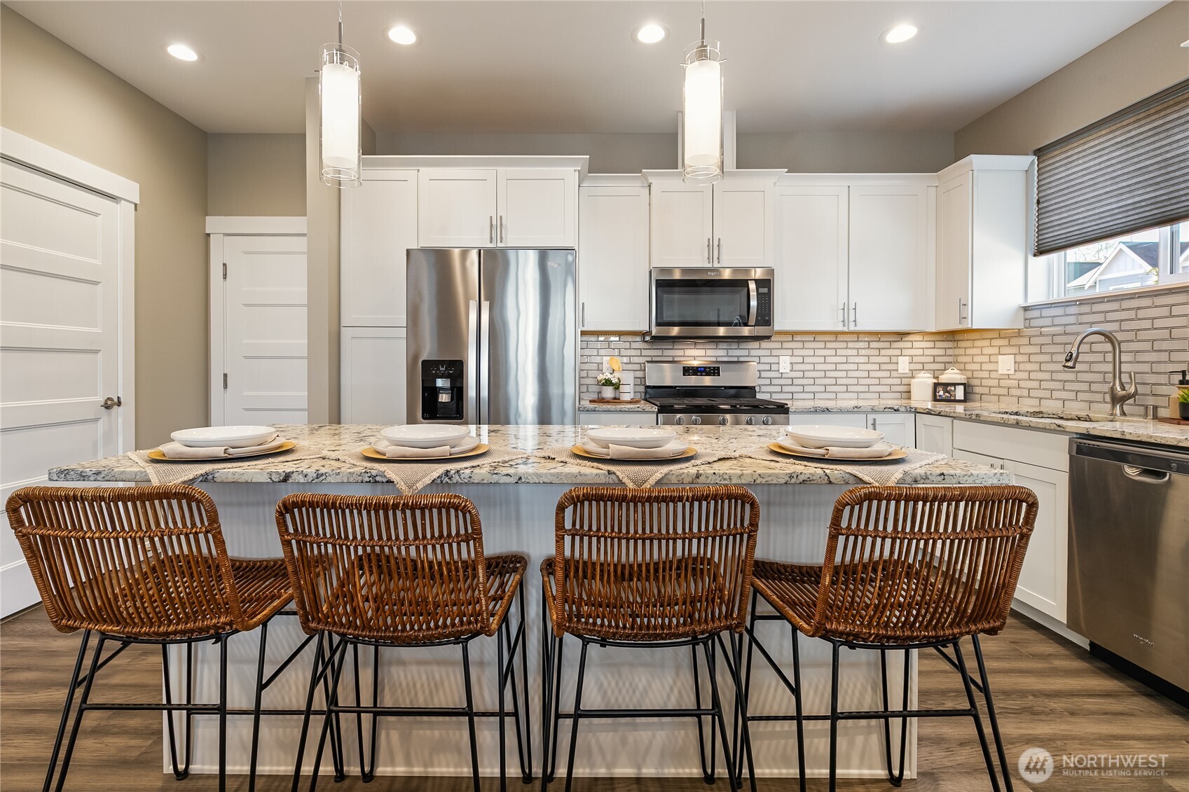 5686 Sunstone Place, Unit 101 Ferndale, WA 98248 - Photo 9 of 32 a kitchen with stainless steel appliances granite countertop a kitchen island a table and chairs