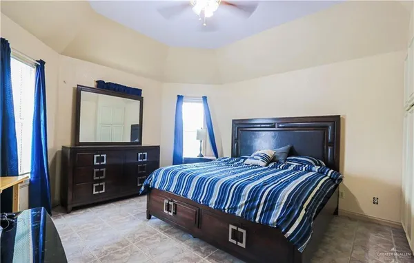 a bedroom with a bed and a flat tv screen on dresser