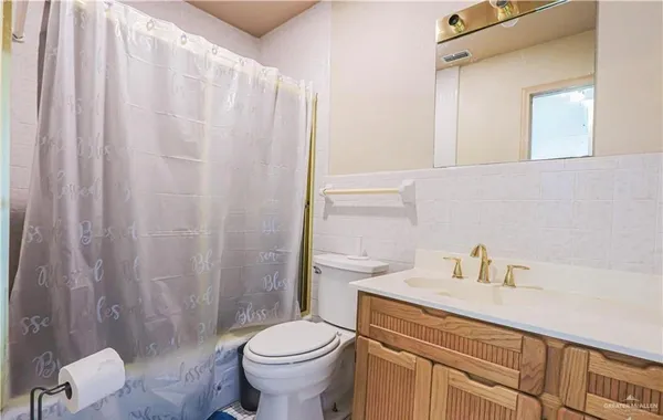 a bathroom with a sink a toilet and shower curtain
